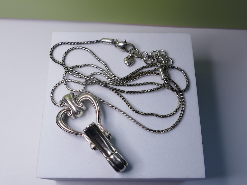 Puede incluir: Collar con colgante de llave plateada. El colgante tiene forma de llave con la parte superior en forma de coraz&oacute;n y un ca&ntilde;&oacute;n detallado. La cadena del collar es de dise&ntilde;o trenzado y delicado, con cierre de mosquet&oacute;n.
