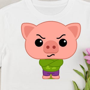 May include: White t-shirt featuring a cartoon pig with an angry expression. The pig is pink with black eyes, a green shirt, and purple pants. The design is centered on the shirt, with a floral arrangement in the background.