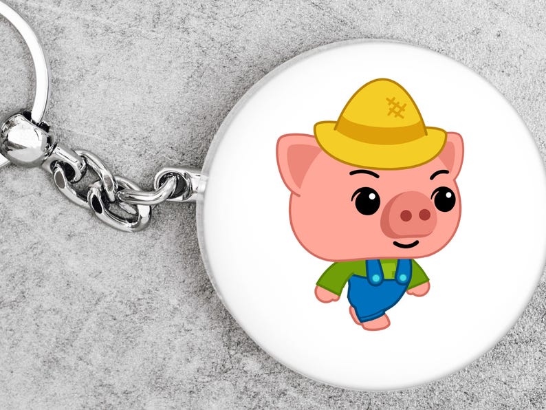 May include: A round keychain with a cartoon pig wearing a yellow hat, green shirt, and blue overalls. The pig has a pink face and a smiling expression. The keychain has a silver chain and ring.