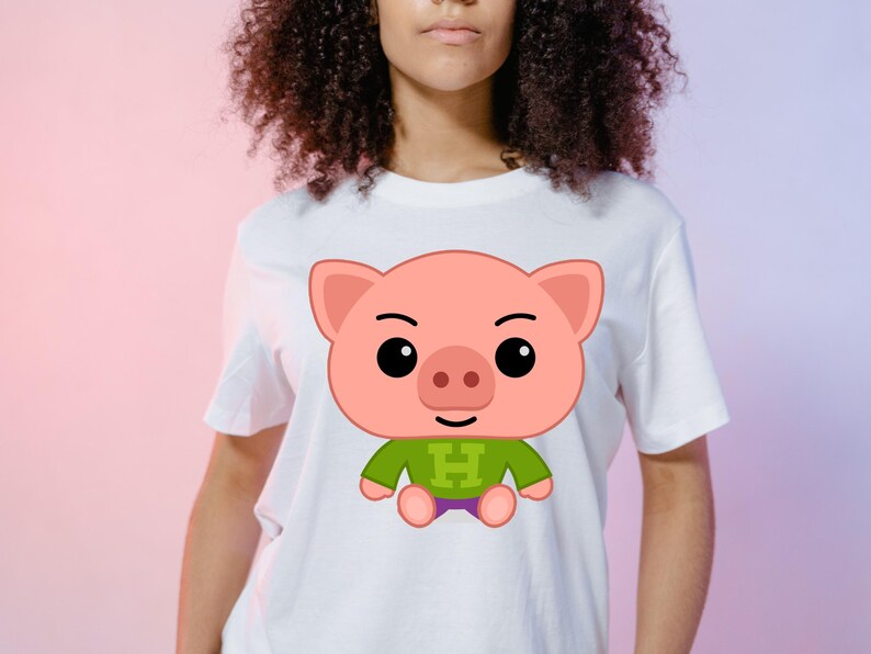 May include: White t-shirt featuring a cartoon pig design. The pig is pink with a green shirt and purple shorts. The letter "H" is on the shirt. The shirt is on a person.