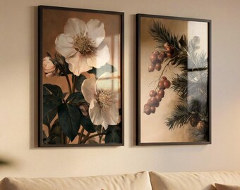 以下が含まれることがあります： 並んで掛けられた2枚の長方形の額入りアートプリント。左のプリントには、濃い緑色の葉を持つ大きな白いヘレボスの花が描かれています。右のプリントには、ベージュの背景に赤い実と松の葉がついた枝が描かれています。