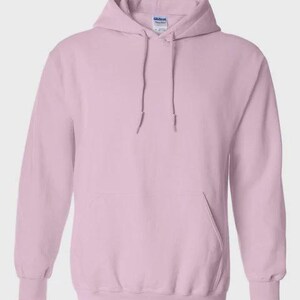 K&ouml;nnte beinhalten: Hellrosa Kapuzenpullover mit Fronttasche und Kordelzugkapuze. Der Pullover hat gerippte B&uuml;ndchen und einen gerippten Saum. Das Markenetikett ist auf der Innenseite der Kapuze sichtbar.