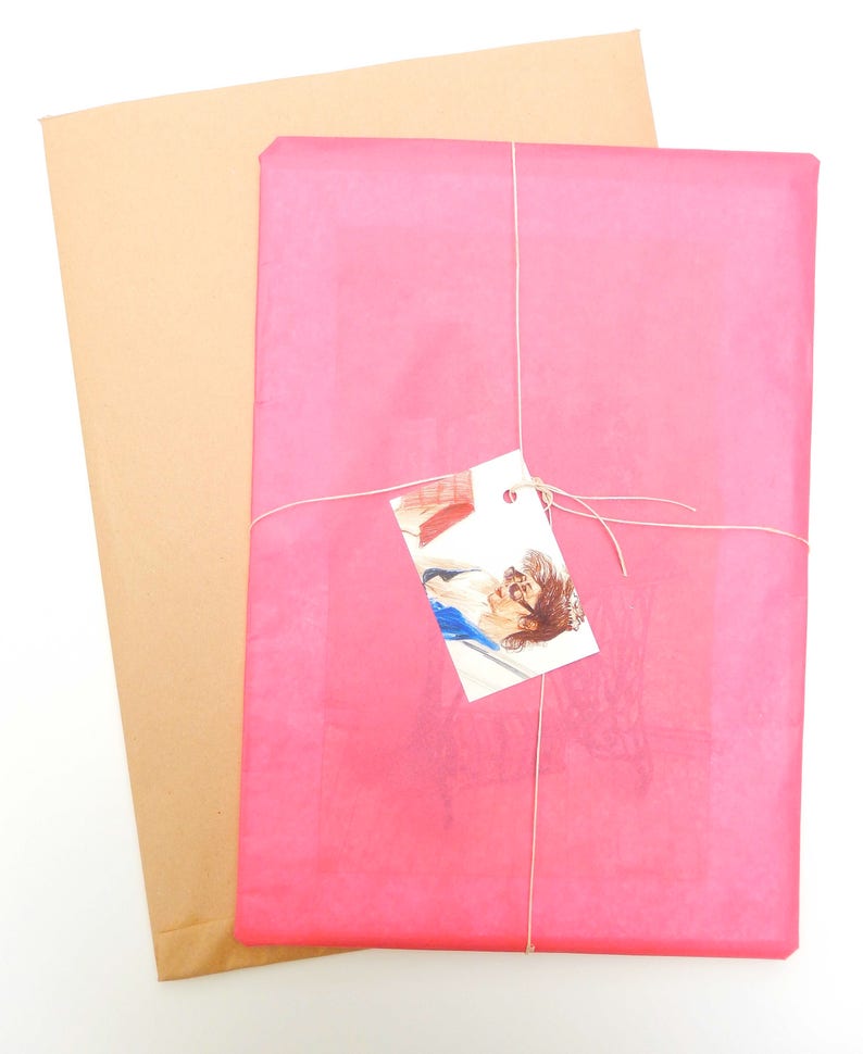 May include: A pink tissue paper package tied with twine and a small white tag. The tag has a drawing of a person with a red book.