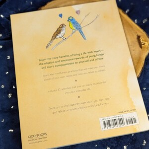 May include: A book cover with a watercolor illustration of two birds perched on a branch, with text about mindfulness and kindness. The book is titled "Mind, Body, Spirit" and includes 52 activities for everyday life.