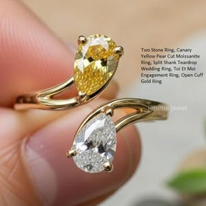 May include: A gold ring featuring two pear-cut gemstones. One is a vibrant yellow, the other is clear. The ring has a split shank design and is labeled as a "Two Stone Ring, Canary Yellow Pear Cut Moissanite Ring, Split Shank Teardrop Wedding Ring, Toi Et Moi Engagement Ring, Open Cuff Gold Ring."