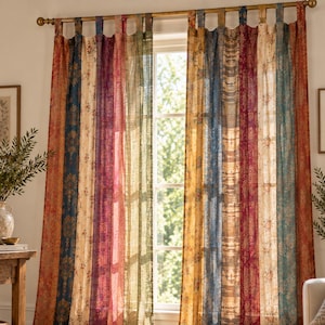 Puede incluir: Un par de cortinas de piso a techo con paneles verticales en varios colores, incluyendo rojo, azul, amarillo, verde y crema. Cada panel muestra un patrón floral o damasco distinto. Las cortinas cuelgan de una barra dorada con trabillas.