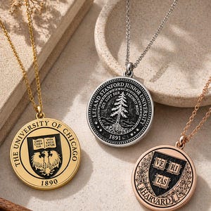 May include: Three round pendant necklaces with chains. One is gold with "THE UNIVERSITY OF CHICAGO" and "1890" text. Another is silver with "LELAND STANFORD JUNIOR UNIVERSITY" and "1891". The third is rose gold with "HARVARD" text.