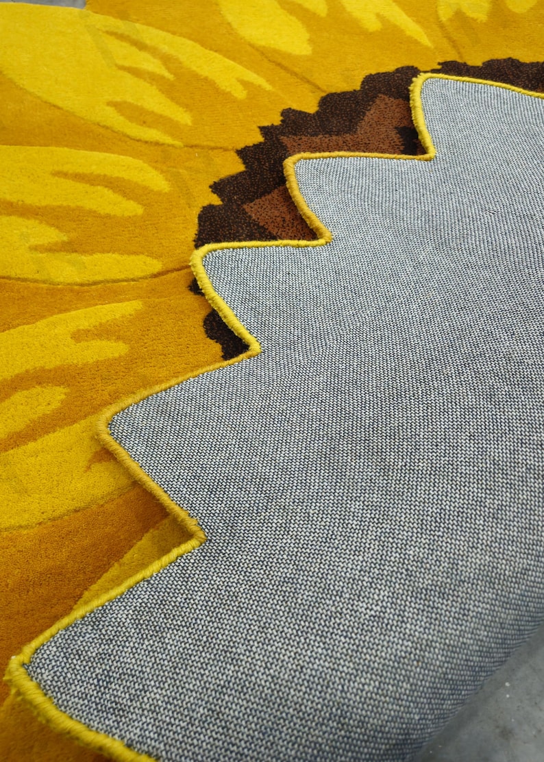 IN-108 Hand Tufted Sunflower Woolen Carpet for Floor Decor, Cozy Home,Bedroom, Courtyard, Living Room, Kids, Cabin, Bedroom, Reading Nook.
A vibrant sunflower-shaped wool rug handcrafted in rich yellow and brown tones, featuring realistic petal textures and a plush wool surface. Displayed in a bright minimalist room with indoor plants, natural sunlight, and a wooden bench, this handmade rug adds a cheerful botanical touch and cozy warmth to any modern living space.