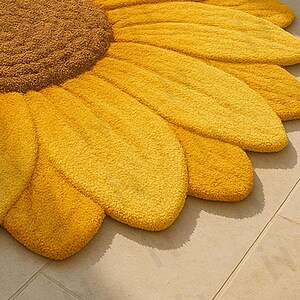IN-108 Hand Tufted Sunflower Woolen Carpet for Floor Decor, Cozy Home,Bedroom, Courtyard, Living Room, Kids, Cabin, Bedroom, Reading Nook.
A vibrant sunflower-shaped wool rug handcrafted in rich yellow and brown tones, featuring realistic petal textures and a plush wool surface. Displayed in a bright minimalist room with indoor plants, natural sunlight, and a wooden bench, this handmade rug adds a cheerful botanical touch and cozy warmth to any modern living space.