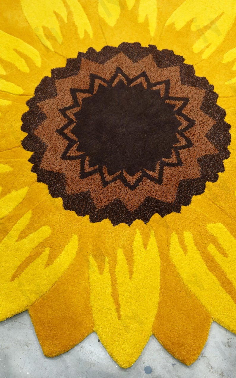 IN-108 Hand Tufted Sunflower Woolen Carpet for Floor Decor, Cozy Home,Bedroom, Courtyard, Living Room, Kids, Cabin, Bedroom, Reading Nook.
A vibrant sunflower-shaped wool rug handcrafted in rich yellow and brown tones, featuring realistic petal textures and a plush wool surface. Displayed in a bright minimalist room with indoor plants, natural sunlight, and a wooden bench, this handmade rug adds a cheerful botanical touch and cozy warmth to any modern living space.