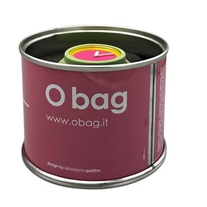 Pu&ograve; includere: Un orologio da polso rosa e verde con una lancetta dei secondi gialla in un contenitore cilindrico di latta rosa e bianco con il testo "O bag" e "www.obag.it" sul lato. Il testo "design by laboratorio.quattro" &egrave; stampato sul fondo del contenitore.