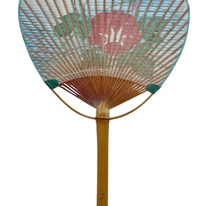 May include: A hand fan with a bamboo handle and ribs. The fan's surface features a floral design with blue and pink flowers against a light blue striped background. The fan is a traditional accessory.