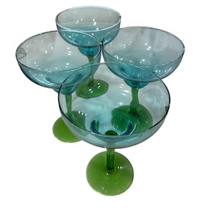 Puede incluir: Cuatro copas de margarita vintage. Los cuencos son de color verde azulado claro, y los tallos y las bases son de un verde vibrante. Las copas son de vidrio y están dispuestas en un patrón circular.
