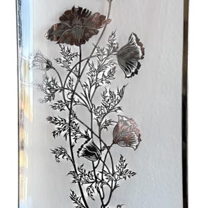 May include: Rectangular glass tray with a silver rim and a floral design. The flowers are in shades of silver and brown, with delicate stems and leaves. The tray is approximately 8 inches long and 4 inches wide.
