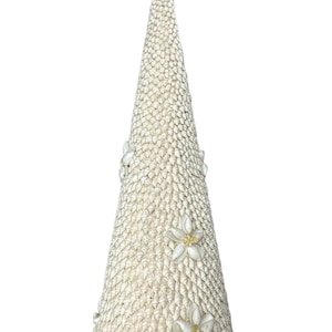 May include: A white seashell Christmas tree with a starfish and seashells on top. The tree is decorated with white flowers.