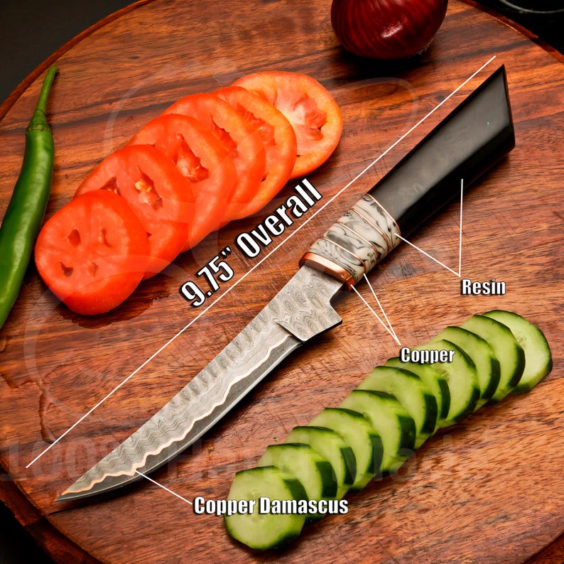 May include: A 9.75-inch overall Damascus steel knife with a black resin handle and copper accents. The knife is shown with sliced tomatoes and cucumbers on a wooden cutting board. The blade has a unique pattern.