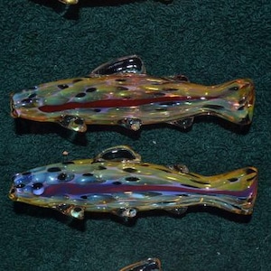 May include: A white ceramic mug with a black handle and the text "But First, Coffee" in a bold, black font. The mug is set against a blurred background, suggesting a cozy setting.