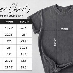 以下が含まれることがあります： グレーのComfort Colors 1717 Tシャツとサイズチャート。 Sから4XLまでのサイズの測定値を示し、幅は46.36cmから75.57cm、長さは67.56cmから85.09cmです。