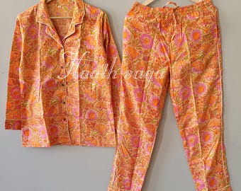 May include: Orange floral print pyjama set. The set includes a button-down collared shirt and matching trousers. The pyjamas are made of a soft fabric and feature a vibrant floral pattern in shades of orange and pink. The text "Maath saga" is visible.