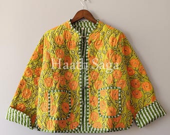 May include: A quilted jacket with a floral pattern in orange and yellow. The jacket has a mandarin collar, two pockets, and green and white striped trim. The text "Haath Saga" is visible on the jacket.
