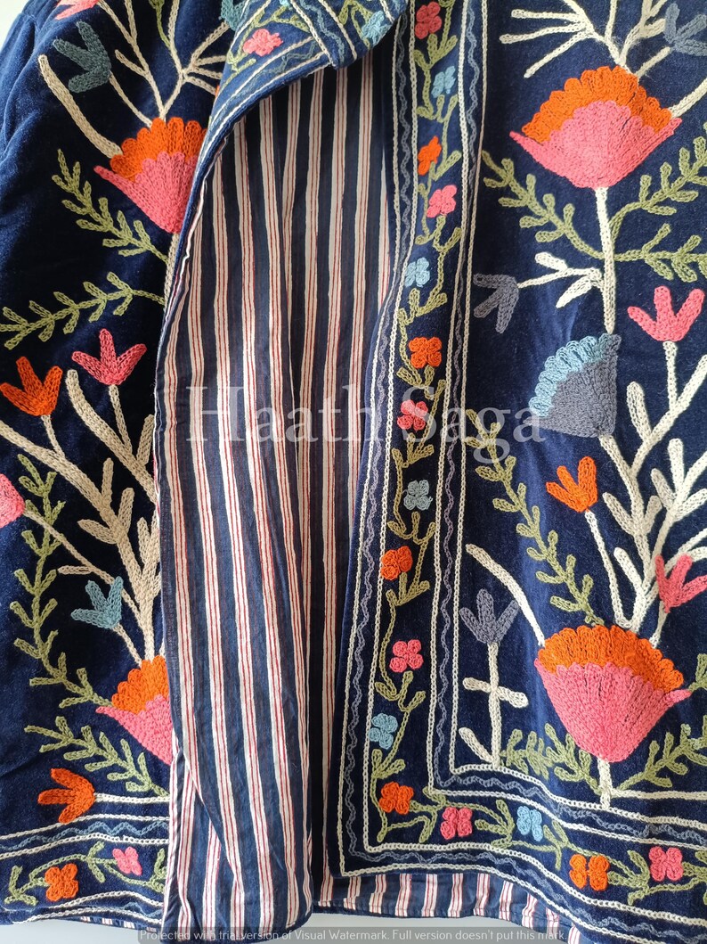 May include: A navy blue embroidered jacket with a striped interior. The jacket features floral embroidery in shades of pink, orange, and blue. The interior lining has vertical red and white stripes.