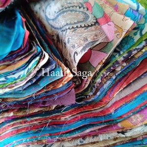 Pode incluir: Uma pilha de retalhos de tecido coloridos em close-up. Os tecidos apresentam várias cores, incluindo azul, vermelho, rosa e verde, com padrões intrincados. O texto "Haath Saga" é visível.