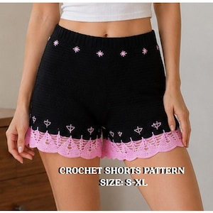 Puede incluir: Pantalones cortos de ganchillo negros con una cintura de patrón de estrellas rosas, una fila de pequeños motivos de lazos bordados en rosa y un dobladillo de encaje rosa festoneado. El texto CROCHET SHORTS PATTERN SIZE: S-XL aparece en blanco.