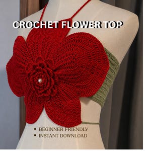 Könnte beinhalten: Ein rotes gehäkeltes Blumentop mit Neckholder-Design. Das Top hat eine große, detaillierte Blume mit Perlenmitte und ein grünes Band am Rücken. Der Text auf dem Bild lautet "CROCHET FLOWER TOP".