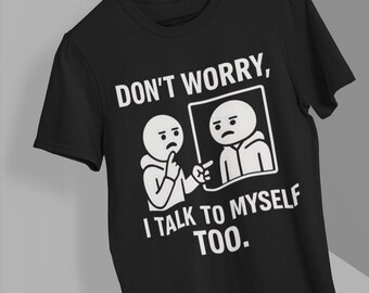 May include: Black t-shirt with a white graphic featuring two stick figures. One figure is pointing at the other inside a frame, with the text "DON'T WORRY, I TALK TO MYSELF TOO."