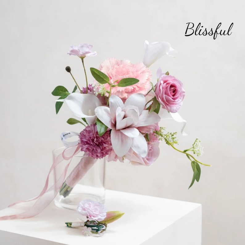 May include: A wedding bouquet with pink, white, and purple flowers, including roses, carnations, and calla lilies. The bouquet is in a clear glass vase and has a matching boutonniere. The word "Blissful" is written in cursive on the image.