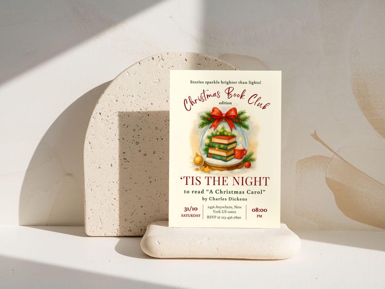 Może przedstawiać: Kremowe zaproszenie na wydanie Christmas Book Club, z akwarelową ilustracją książek w kuli śnieżnej, czerwoną kokardą i tekstem "'Tis the Night to read 'A Christmas Carol'" autorstwa Charlesa Dickensa.