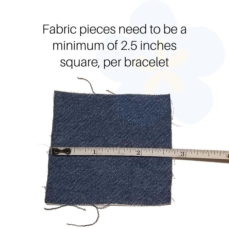 May include: A square piece of dark blue denim fabric measuring 2.5 inches across, as indicated by a white measuring tape placed horizontally over the material. The text above reads: Fabric pieces need to be a minimum of 2.5 inches square, per bracelet.