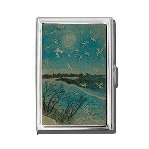 May include: A silver cigarette case featuring a whimsical illustration. The artwork depicts a night scene with a full moon, silhouetted trees, and numerous flying figures against a blue background. The case has a shiny, metallic finish.