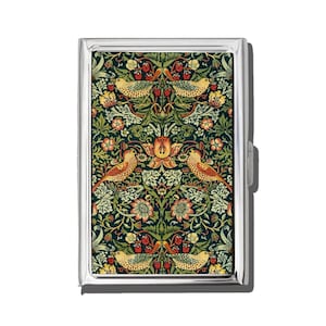 May include: A silver metal cigarette case with a colorful floral and bird pattern. The design features birds, flowers, and berries in shades of green, orange, and yellow against a dark background. The case has a rectangular shape and a clasp closure.