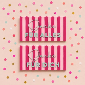 May include: Two rectangular signs with a pink and dark pink vertical striped pattern. The top sign features the text "Danke FÜR ALLES" in a mix of script and block lettering. The bottom sign features the text "Danke FÜR DICH" in the same style.