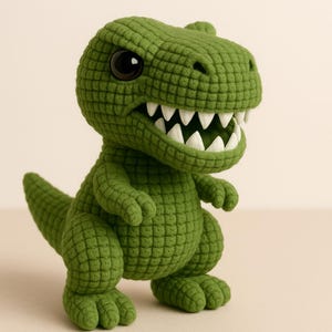 Puede incluir: Un juguete de dinosaurio Tyrannosaurus Rex verde tejido a ganchillo con grandes ojos negros y dientes blancos. El dinosaurio tiene un patrón texturizado en forma de rejilla y está de pie. El juguete mide aproximadamente 20 cm de alto.