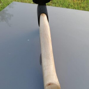Pu&ograve; includere: Un'ascia nera e di legno con un manico in legno di colore chiaro. La testa dell'ascia &egrave; nera e il manico &egrave; in legno chiaro. L'ascia &egrave; progettata per tagliare e spaccare la legna.