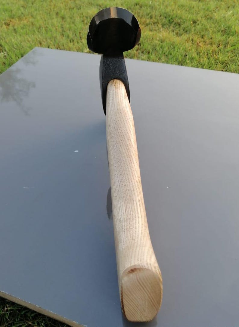 Pu&ograve; includere: Un'ascia nera e di legno con un manico in legno di colore chiaro. La testa dell'ascia &egrave; nera e il manico &egrave; in legno chiaro. L'ascia &egrave; progettata per tagliare e spaccare la legna.