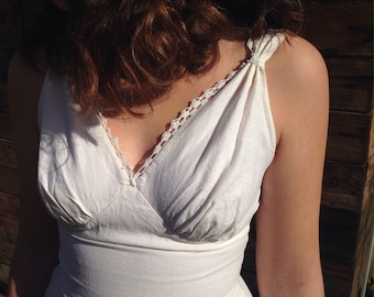 May include: A white sleeveless dress with a crocheted trim and a gathered bodice.