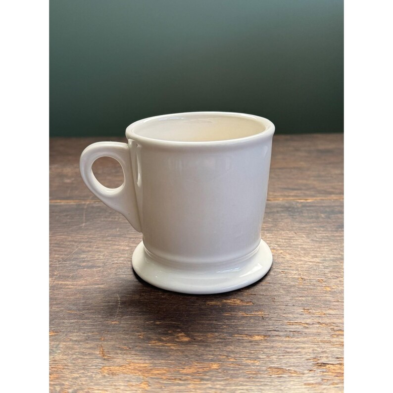 May include: A set of three ceramic mugs with a speckled, matte finish. The mugs are in shades of cream, light gray, and dark gray. Each mug has a simple, minimalist design, perfect for coffee or tea.