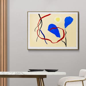 Può includere: Stampa d'arte astratta in una cornice dorata. L'opera presenta uno sfondo color crema con forme audaci: due forme blu a goccia, un cerchio giallo e linee curve rosse e nere. L'opera è esposta su una parete.