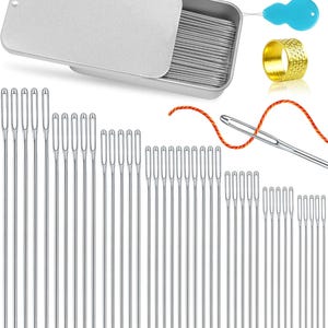 May include: A collection of sewing needles in various sizes, displayed with a metal tin, needle threaders, and a gold thimble. The needles are silver, and the threaders are red and blue. An orange thread is shown threaded through a needle.