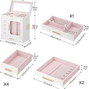 May include: A white jewelry box with a mirror, drawers, and compartments. The box is 10.6 inches wide, 10.2 inches tall, and 5.5 inches deep. It has gold-colored handles and a pink interior. Includes four drawers and a top compartment.