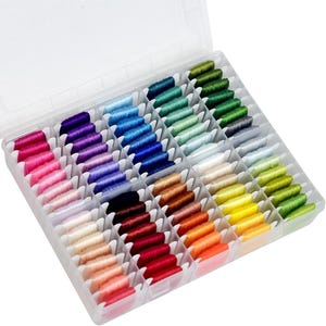 May include: A clear plastic organizer filled with colorful embroidery floss. The floss is arranged in neat rows, showcasing a spectrum of colors from pinks and purples to blues, greens, yellows, oranges, and reds. The threads are neatly wound, ready for crafting.