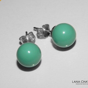 May include: A pair of silver stud earrings with turquoise round stones.