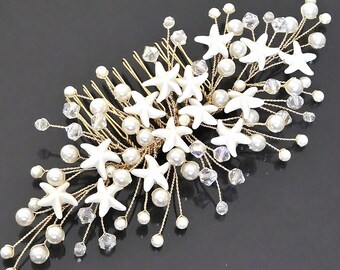 May include: A gold-toned hair comb adorned with white starfish, faux pearls, and clear crystal accents. The comb features a delicate design, perfect for weddings or special occasions. The comb's dimensions are approximately 4 inches in length.