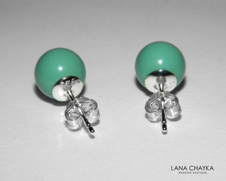 May include: A pair of silver stud earrings with turquoise round beads. The earrings have a post and butterfly back.