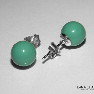 May include: A pair of silver stud earrings with turquoise round beads.