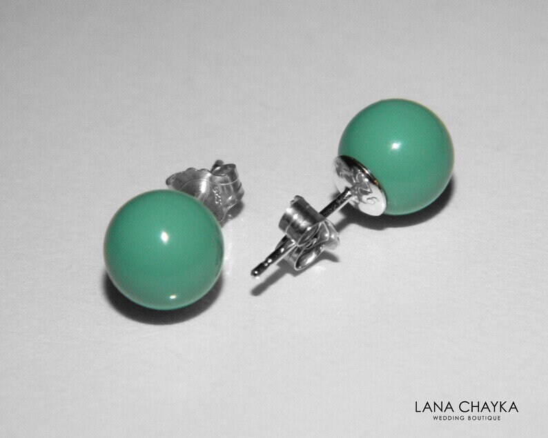 May include: A pair of silver stud earrings with turquoise round beads.