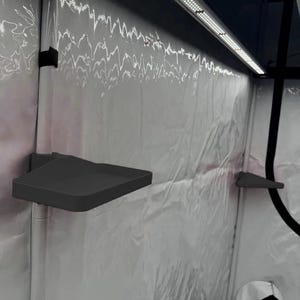 Peut inclure: Intérieur d'une tente de culture avec une doublure argentée réfléchissante. Deux étagères triangulaires gris foncé sont fixées au mur. Une bande lumineuse LED est fixée en haut. La tente est conçue pour le jardinage d'intérieur.